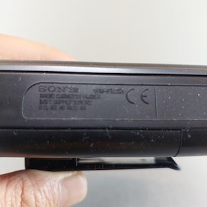 May include: Close-up of a black Sony Radio Cassette Player. The text on the device includes the brand name, model number, and other technical specifications. A CE mark is also visible.
