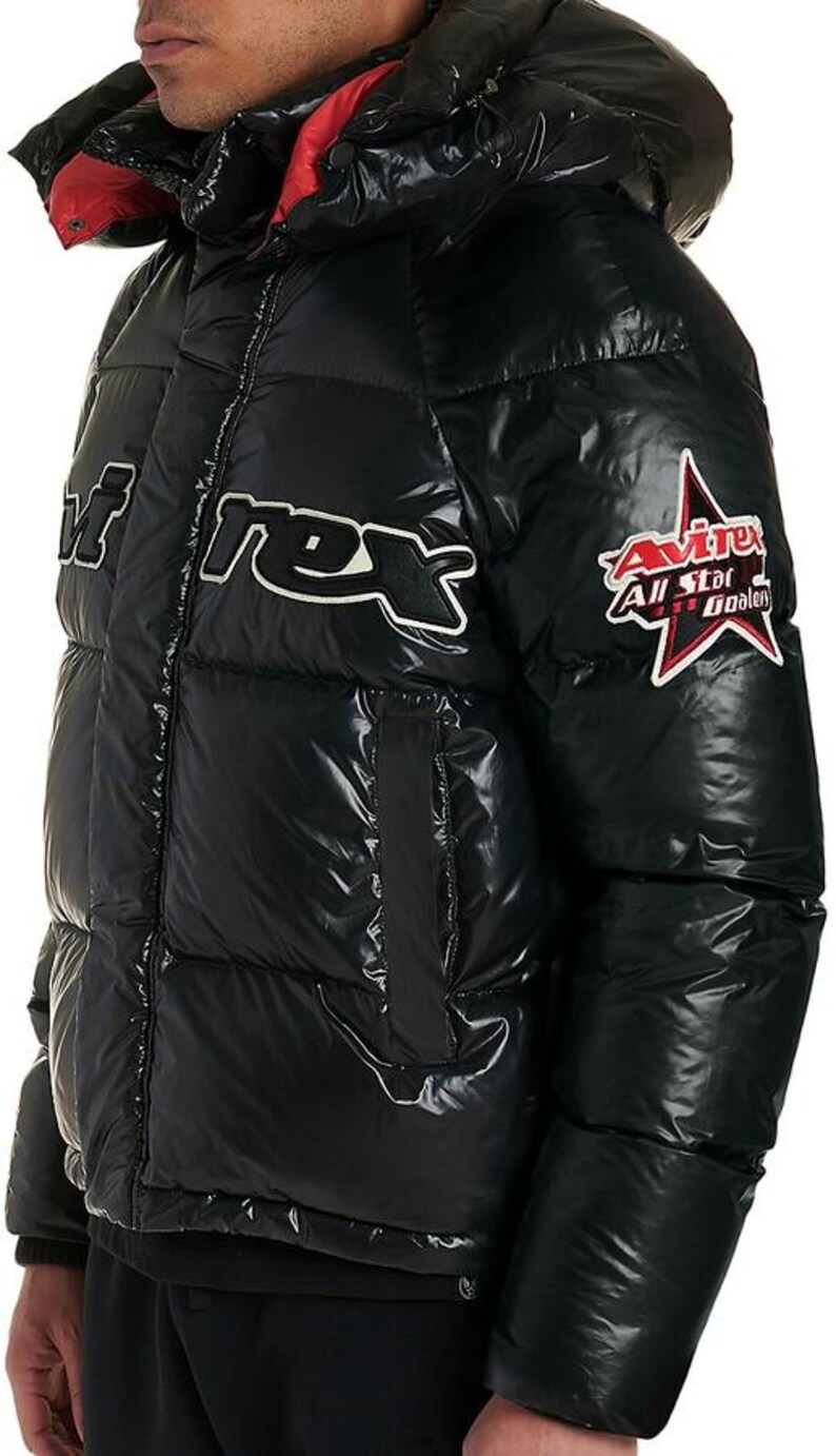 May include: Black puffer jacket with a glossy finish, featuring a hood with red lining. The jacket has white text and a star-shaped patch with text. A winter coat.