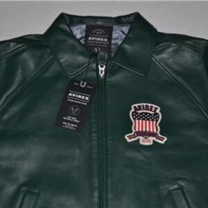 May include: A set of three ceramic mugs with a speckled, cream-colored glaze. Each mug features a different hand-painted floral design in shades of blue, green, and yellow. The mugs have a simple, rounded shape and a comfortable handle.