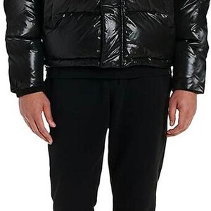 May include: Black puffer jacket with a hood and red lining. The jacket has the word "Avirex" in white lettering across the chest. The person is wearing black sweatpants and white sneakers.