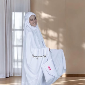 May include: A white prayer garment set, comprising a head covering and a matching carrying case. The set is made of a soft, flowing fabric. The carrying case has the word "Nebula" in pink. The image also includes the text "MaryonoArt".