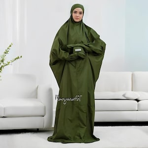 May include: A long, loose-fitting, green prayer robe with a matching head covering. The robe has a pocket on the chest and is made of a smooth, lightweight fabric.