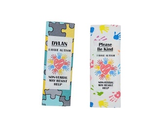 May include: Two autism awareness wristbands. One features a puzzle piece design with the name "DYLAN" and the text "I HAVE AUTISM." The other has handprints and the text "Please Be Kind." Both say "NON-VERBAL MAY RESIST HELP."