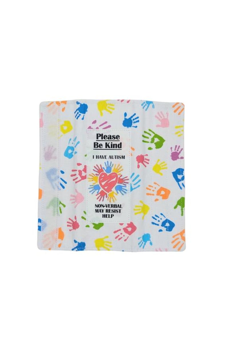 May include: White cloth with colorful handprints and text. The center features a heart and the words "Please Be Kind, I Have Autism, Non-Verbal May Resist Help."