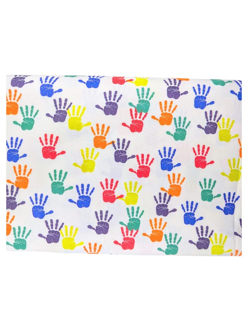 May include: White fabric with a repeating pattern of colorful handprints in red, orange, yellow, green, blue, and purple. The handprints are evenly spaced across the fabric.