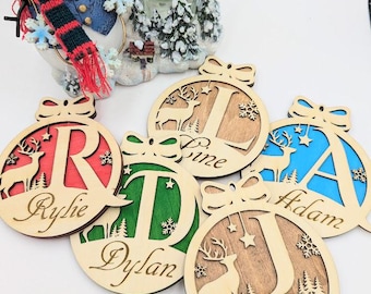 May include: Five wooden Christmas ornaments with a reindeer and a letter cutout. Each ornament has a different name: Rylie, Dylan, June, Adam, and Jessyka.