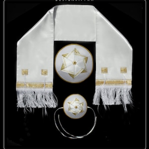 Op de afbeelding: Een witte satijnen tallit met gouden rand en kwastjes, een witte kippa met een gouden Davidster en een kleinere witte kippa met een gouden Davidster.