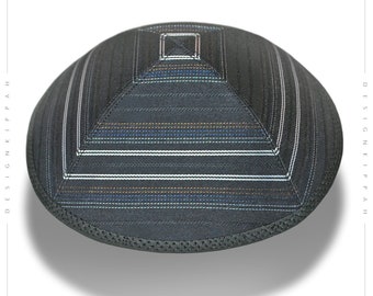 May include: A black kippah with a striped pattern in white, blue, and gold. The kippah has a square top and a rounded bottom.