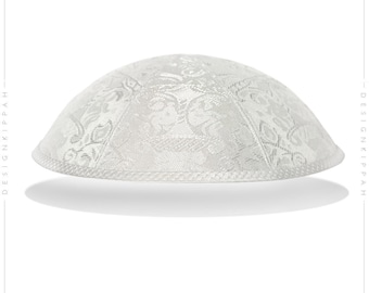 Puede incluir: Kipá blanca con un patrón floral plateado.