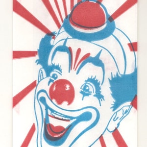 May include: A vintage popcorn bag with a red, white, and blue color scheme. The bag features a cartoon clown with a big smile and the words "POP CORN" in a blue circle. The bag also says "CRISP, DELICIOUS, FRESH".