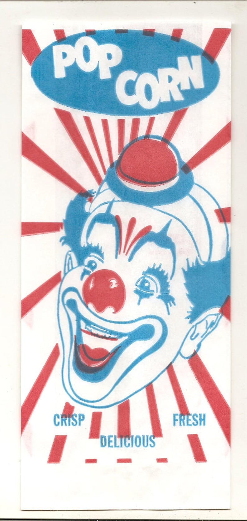 May include: A vintage popcorn bag with a red, white, and blue color scheme. The bag features a cartoon clown with a big smile and the words "POP CORN" in a blue circle. The bag also says "CRISP, DELICIOUS, FRESH".