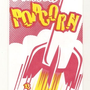 May include: A red and yellow popcorn bag with a rocket design and the text "Action Popcorn".