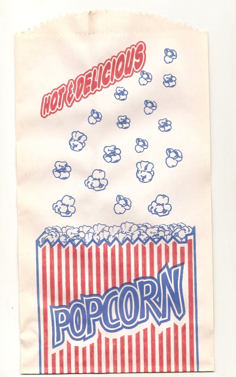 May include: A white paper bag with red and blue stripes at the bottom. The bag has the words "HOT & DELICIOUS" printed in red and "POPCORN" printed in blue. The bag is decorated with blue popcorn kernels.