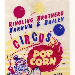 May include: A vintage paper bag with a yellow, red, and blue circus theme. It features the Ringling Brothers and Barnum & Bailey Circus logo, a clown holding a popcorn box, and the text "Pop Corn" in a red circle.