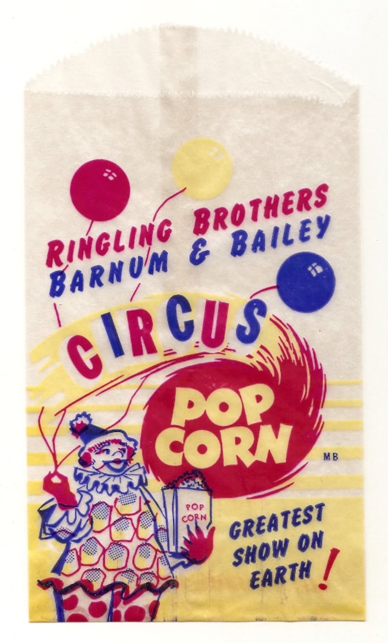 May include: A vintage paper bag with a yellow, red, and blue circus theme. It features the Ringling Brothers and Barnum & Bailey Circus logo, a clown holding a popcorn box, and the text "Pop Corn" in a red circle.