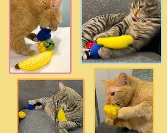 May include: Four orange tabby cats playing with crocheted fruit toys. The toys are shaped like bananas, pineapples, and strawberries. The cats are on different colored surfaces.