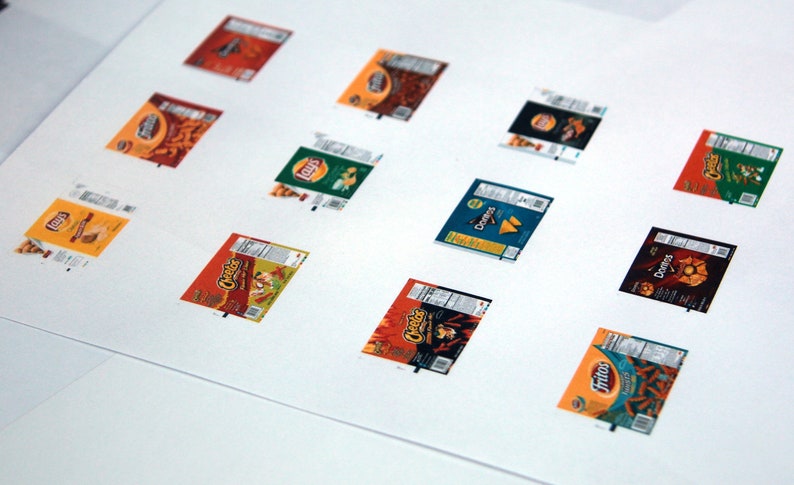 May include: A white sheet of paper with 12 different chip bag designs. The bags are all different colors and have different logos. The bags are arranged in a grid pattern.