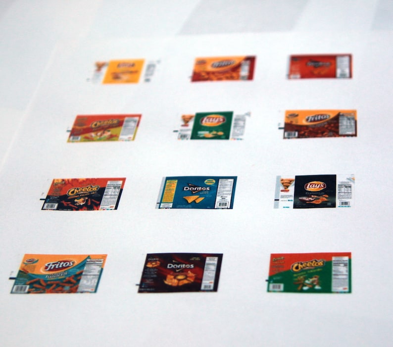 May include: A white sheet of paper with nine different snack food bag designs. The bags are all different colors and have different logos. The logos include: Lay's, Doritos, Cheetos, Fritos, and Tostitos.