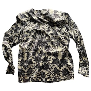 May include: A long-sleeved blouse with a floral print in shades of black and cream.
