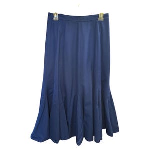 May include: A navy blue midi skirt with a flared hem. The skirt has a simple design and is made of a smooth fabric.