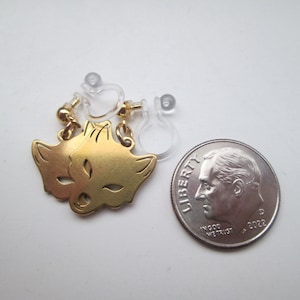 May include: A pair of gold-tone fox face clip-on earrings. The earrings are about the size of a dime.