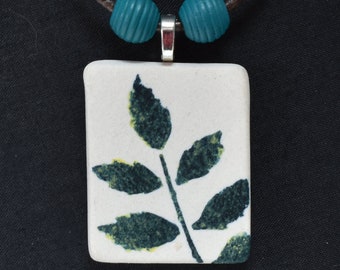 ceramic pendant with ferns. 3mm leather cord, stainless bayonet clasp. one of a kind.