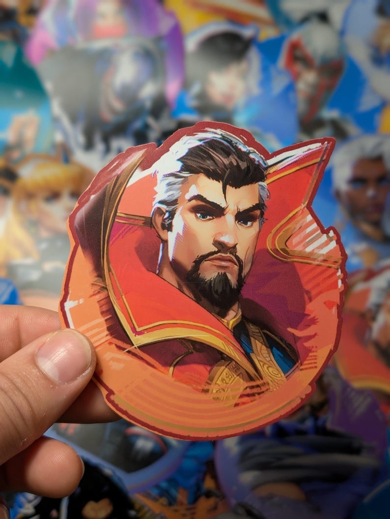 May include: A sticker featuring a cartoon illustration of a man with a beard wearing a red and gold robe. The man has a serious expression on his face. The sticker is on a white background.