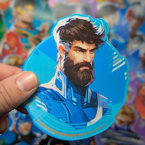 May include: A blue and white sticker featuring a cartoon illustration of a man with a beard and a blue and white uniform. The sticker is circular and has a gold outline.