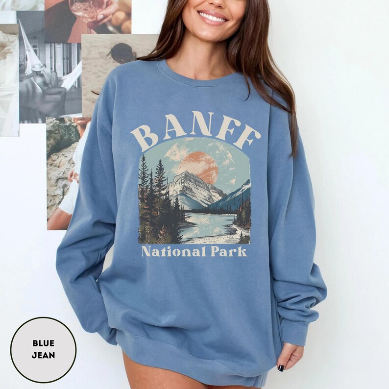May include: A blue jean sweatshirt with a graphic print of a mountain landscape and the text "Banff National Park".