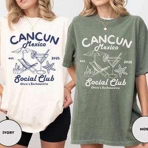 May include: Two oversized t-shirts with a graphic design of a cocktail, lounge chair, and palm tree. The text on the shirts reads "Cancun Mexico est. 2025 Social Club Olivia's Bachelorette". The shirts are shown in ivory and moss.