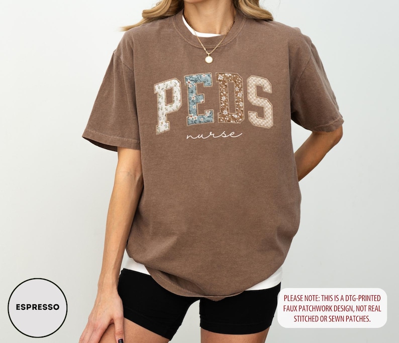May include: Espresso-colored t-shirt with the word "PEDS" in a faux patchwork design, and the word "nurse" in a script font. The shirt has a relaxed fit and short sleeves. The text "PLEASE NOTE: THIS IS A DTG-PRINTED FAUX PATCHWORK DESIGN, NOT REAL STITCHED OR SEWN PATCHES." is also visible.