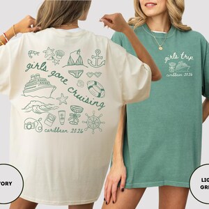 Puede incluir: Dos camisetas, una marfil y otra verde claro, con dise&ntilde;os tem&aacute;ticos de cruceros. La camiseta marfil tiene "girls gone cruising caribbean 2026" con ilustraciones n&aacute;uticas. La camiseta verde claro dice "girls trip caribbean 2026" con un crucero.