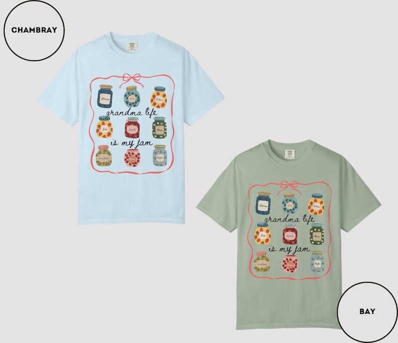 Peut inclure: Deux t-shirts &agrave; manches courtes, un bleu clair et un vert sauge. Chaque t-shirt pr&eacute;sente un motif de bocaux de confiture avec le texte "grandma life is my jam" dans un cadre rose.