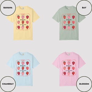 May include: Four short-sleeved t-shirts in different colors: yellow, green, light blue, and pink. Each shirt features a strawberry graphic with the text "nicu is my jam" inside a decorative frame. The shirts are displayed on a light gray background.