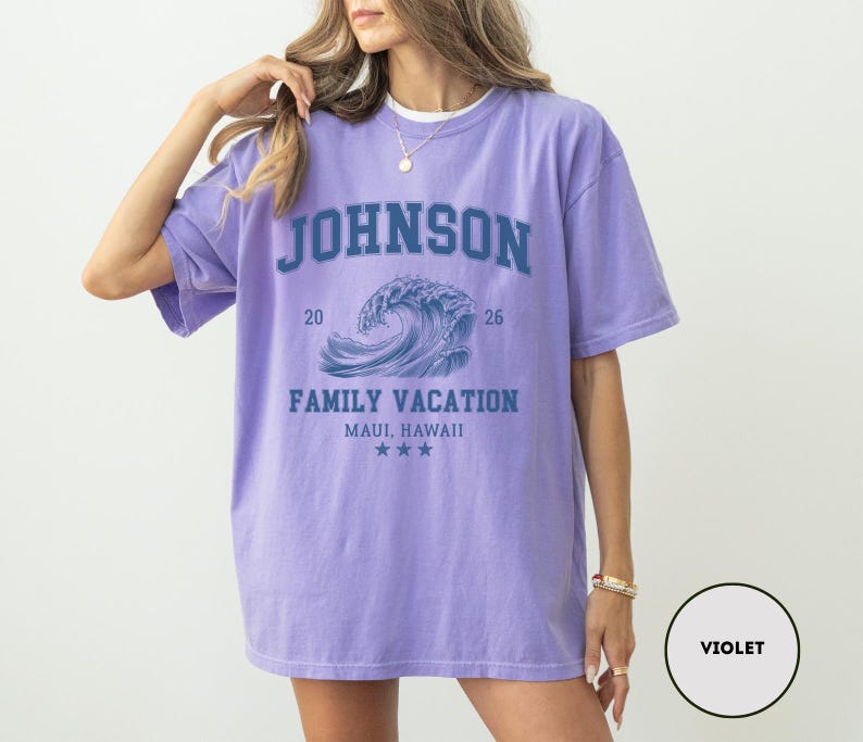 K&ouml;nnte beinhalten: Violettes T-Shirt mit kurzen &Auml;rmeln und Rundhalsausschnitt. Auf der Vorderseite steht in blauen Blockbuchstaben "JOHNSON" &uuml;ber einer blauen Wellengrafik. Darunter steht "FAMILY VACATION MAUI, HAWAII" und drei Sterne.