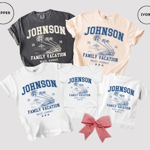 K&ouml;nnte beinhalten: Familienurlaubs-T-Shirts in Grau, Creme und Wei&szlig;. Jedes Shirt zeigt den Namen "Johnson", den Text "Family Vacation Maui, Hawaii" und eine Palmen-Grafik. Eine rot-wei&szlig; karierte Schleife befindet sich unten.