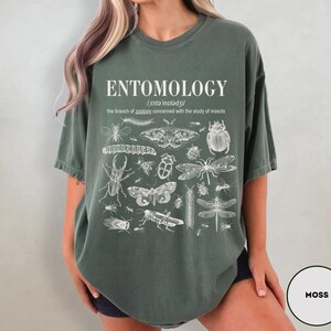May include: A moss green oversized t-shirt with a white graphic print of various insects and the text "ENTOMOLOGY /ˌɛntəˈmɒlədʒi/ the branch of zoology concerned with the study of insects."