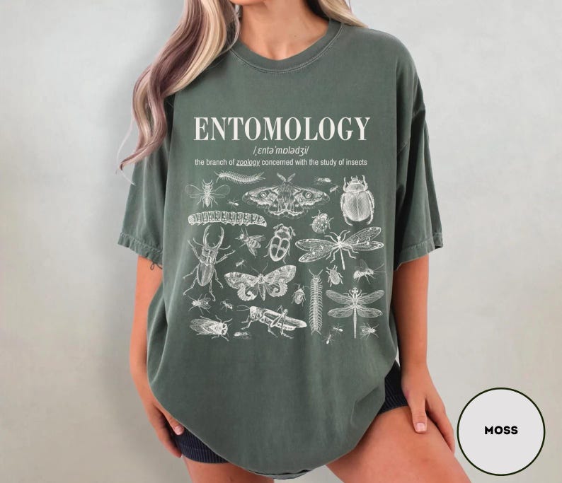 May include: A moss green oversized t-shirt with a white graphic print of various insects and the text "ENTOMOLOGY /ˌɛntəˈmɒlədʒi/ the branch of zoology concerned with the study of insects."