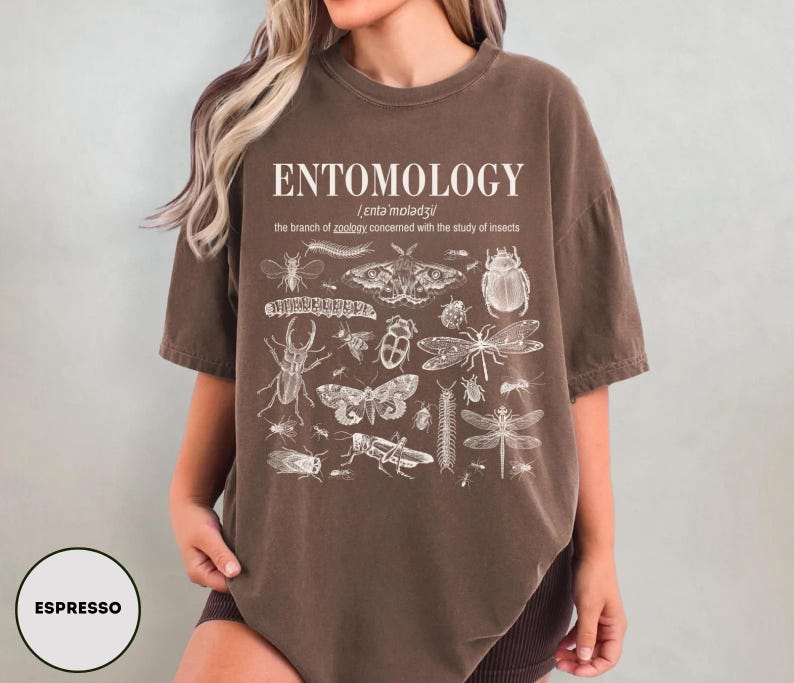 May include: A brown t-shirt with a white print of insects and the text "ENTOMOLOGY /enta moladzil/ the branch of zoology concerned with the study of insects"