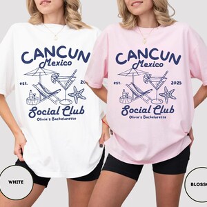 May include: Two white and pink oversized t-shirts with a graphic design of a beach scene with a cocktail, lounge chair, and the text "CANCUN Mexico est. 20 Social Club Olivia's Bachelorette 2025".