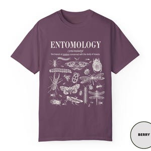 May include: Purple t-shirt with a white graphic print of insects and the word "ENTOMOLOGY" with the definition "the branch of zoology concerned with the study of insects".