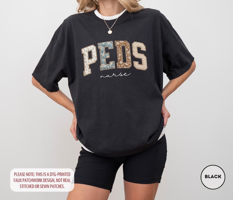 May include: Black t-shirt with the word "PEDS" in a faux patchwork design, with the word "nurse" underneath. The shirt is a relaxed fit and has a white crew neck collar. The text "PLEASE NOTE: THIS IS A DTG-PRINTED FAUX PATCHWORK DESIGN, NOT REAL STITCHED OR SEWN PATCHES." is at the bottom.