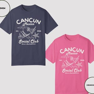 May include: Two t-shirts with a white graphic design of a beach scene with a cocktail, lounge chair, and palm tree. The text on the shirts reads "Cancun Mexico Social Club Olivia's Bachelorette" with the years "est. 2025". One shirt is navy blue and the other is pink.