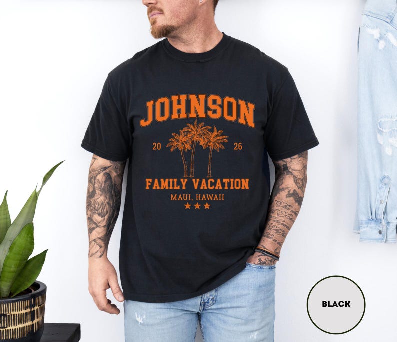 K&ouml;nnte beinhalten: Schwarzes T-Shirt mit orangefarbenem Text "JOHNSON" &uuml;ber einer Grafik von drei Palmen und den Worten "FAMILY VACATION MAUI, HAWAII". Das Shirt hat auch die Zahlen "20" und "26" und drei Sterne.