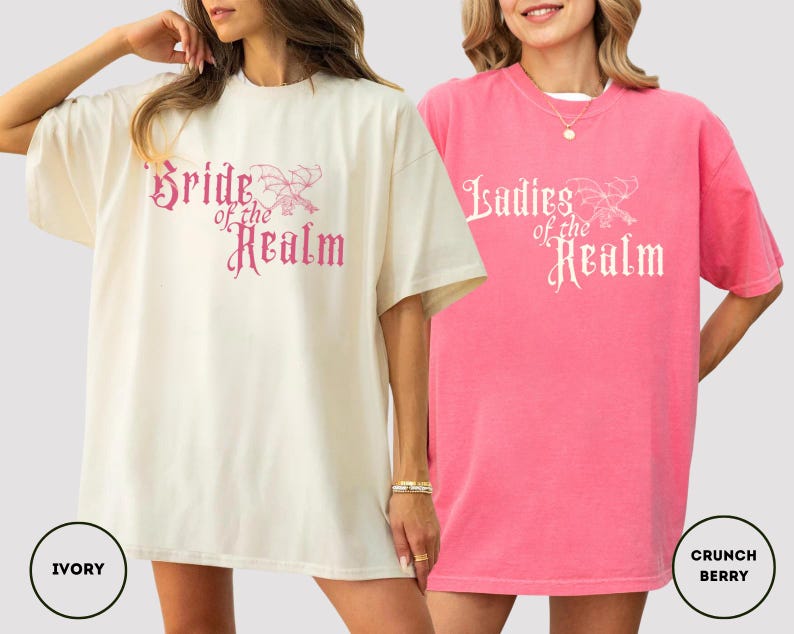 May include: Two oversized t-shirts, one ivory and one pink, with the text "Bride of the Realm" and "Ladies of the Realm" in a decorative font. The ivory shirt has a matching ivory circle with the word "IVORY". The pink shirt has a matching pink circle with the words "CRUNCH BERRY".