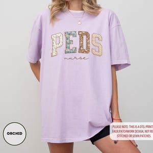 May include: A light purple t-shirt with the word "PEDS" in a patchwork design, with the word "nurse" underneath. The shirt also has the word "ORCHID" in a circle on the bottom left. The shirt is a DTG-printed faux patchwork design.