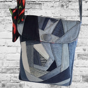 May include: A denim patchwork crossbody bag with a flap closure and a long strap. The bag features a variety of blue denim shades and a decorative fabric with red chili peppers.