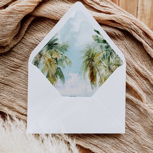 May include: A white envelope with a watercolor illustration of palm trees and a blue sky on the front.