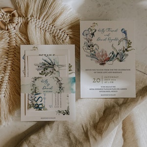 May include: Wedding invitation suite featuring watercolor illustrations of coral and sea life. The invitation includes the names Kelly & David, the date July 20, 2024, and the location in Riviera Maya, Mexico. The suite includes RSVP cards.
