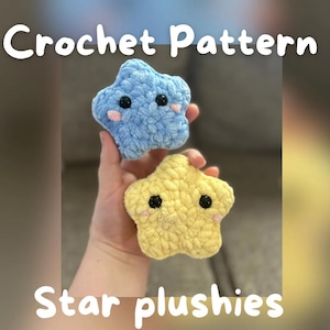 May include: Two crocheted star-shaped plushies, one light blue and one yellow, each with black eyes and pink cheeks. The text "Crochet Pattern" and "Star plushies" are displayed in white font.